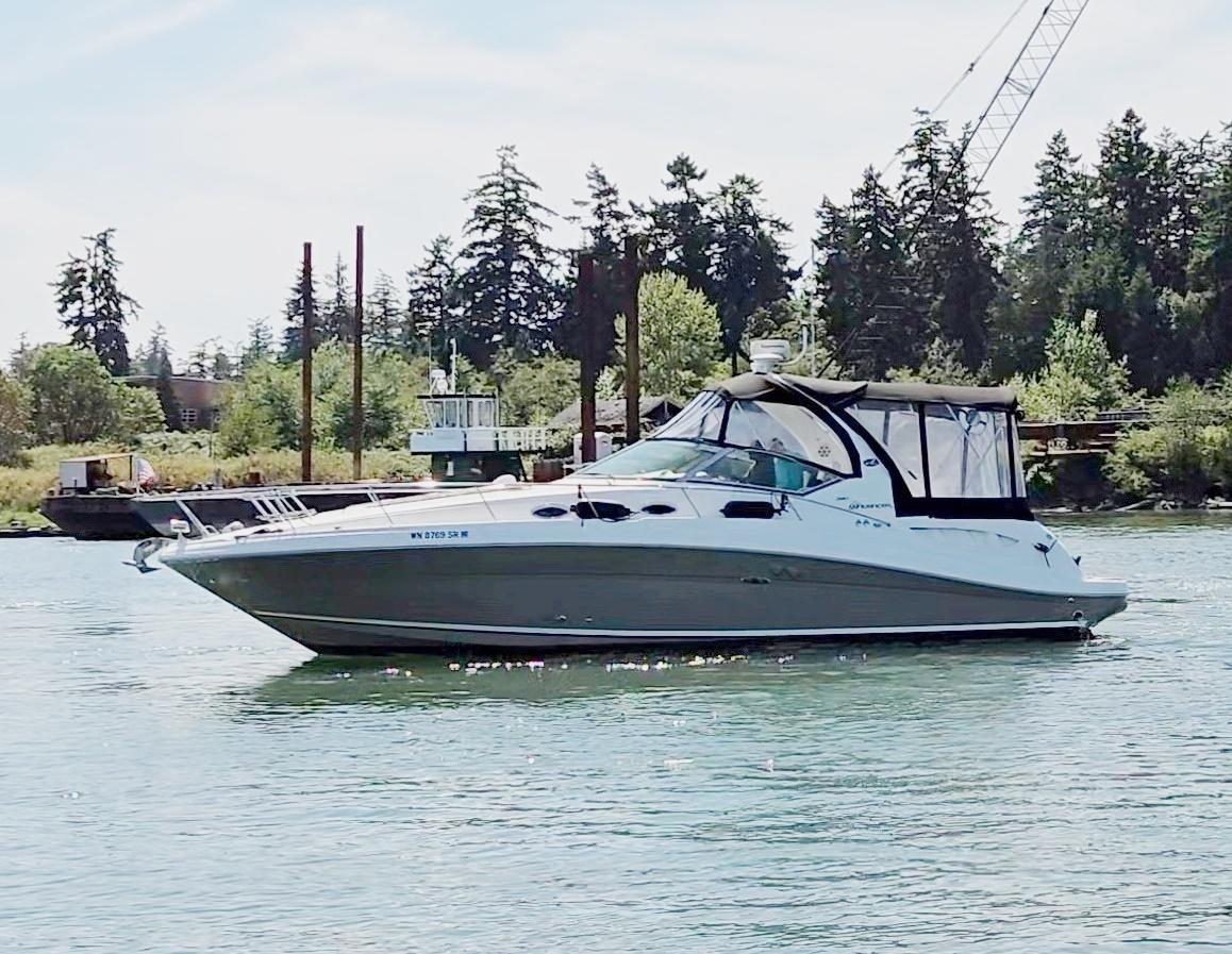 Sea Ray 340 Sundancer 2007 Sea Ray 340 Sundancer yacht on calm water, surrounded by trees and industrial structures.