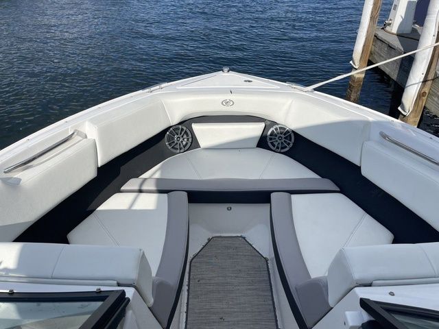 Cobalt CS22 2024 Cobalt CS22 boat interior with white seating, docked by the water.