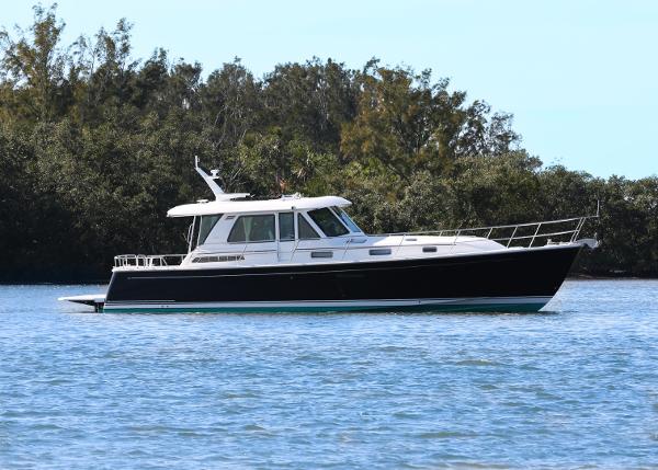 Sabre 48 Salon Express 2025 Sabre 48 Salon Express yacht on calm water, surrounded by trees.