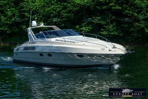 Riva Tropicana 1989 Riva Tropicana boat cruising on a serene lake with lush green trees in the background.