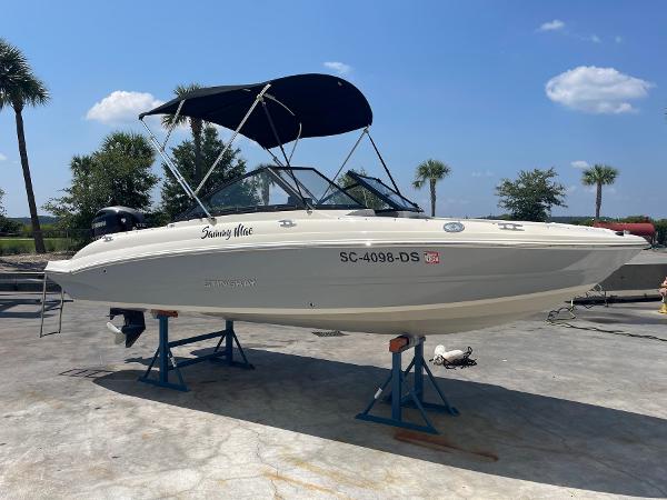 Stingray 191 DC 2021 Stingray 191 DC boat on stands, with canopy, outdoors under blue sky.