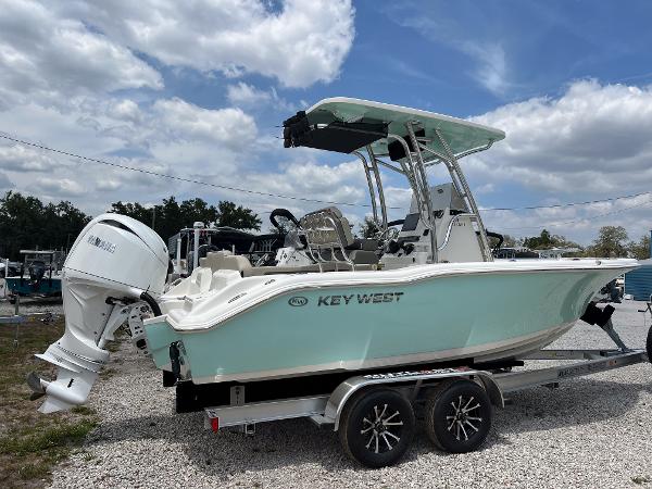 Key West 219 FS 2025 Key West 219 FS boat on trailer, white and mint green, under cloudy sky.