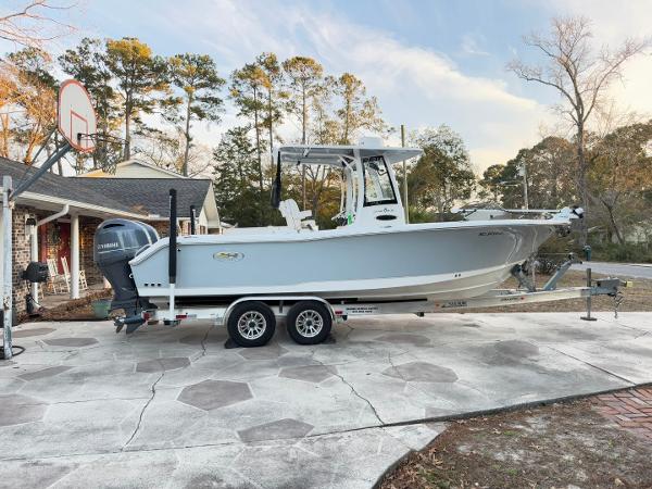 Sea Hunt Gamefish 25 2023 Sea Hunt Gamefish 25 boat on trailer in driveway, surrounded by trees.