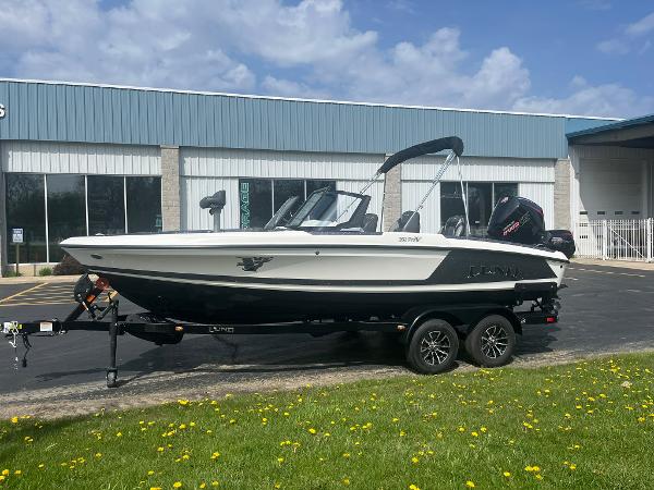 Lund 202 Pro-V GL 2025 Lund 202 Pro-V GL boat on trailer, parked outside a building on a sunny day.