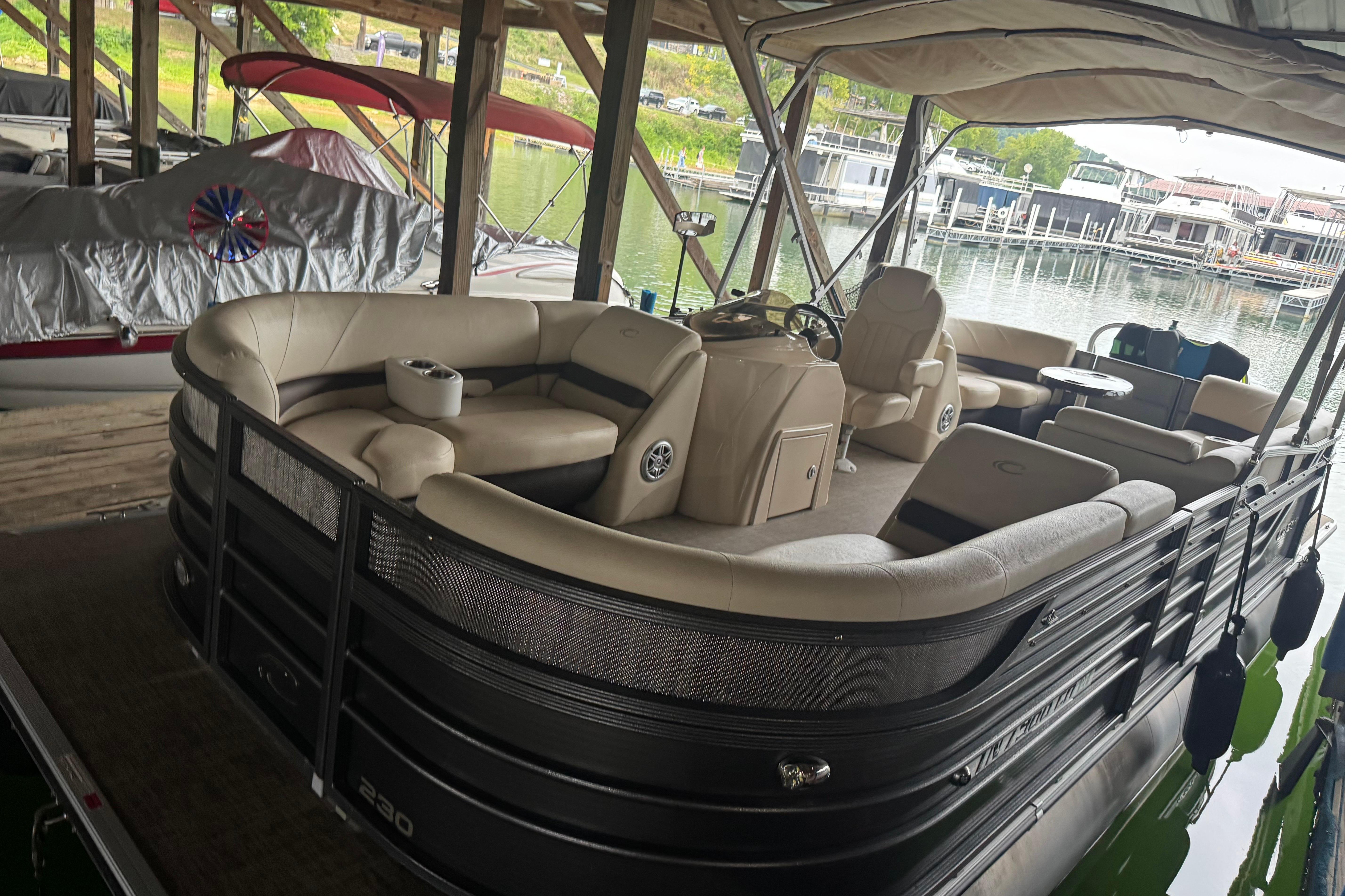 Crest Crest III 2015 Crest III pontoon boat with beige seating, docked under a covered marina.
