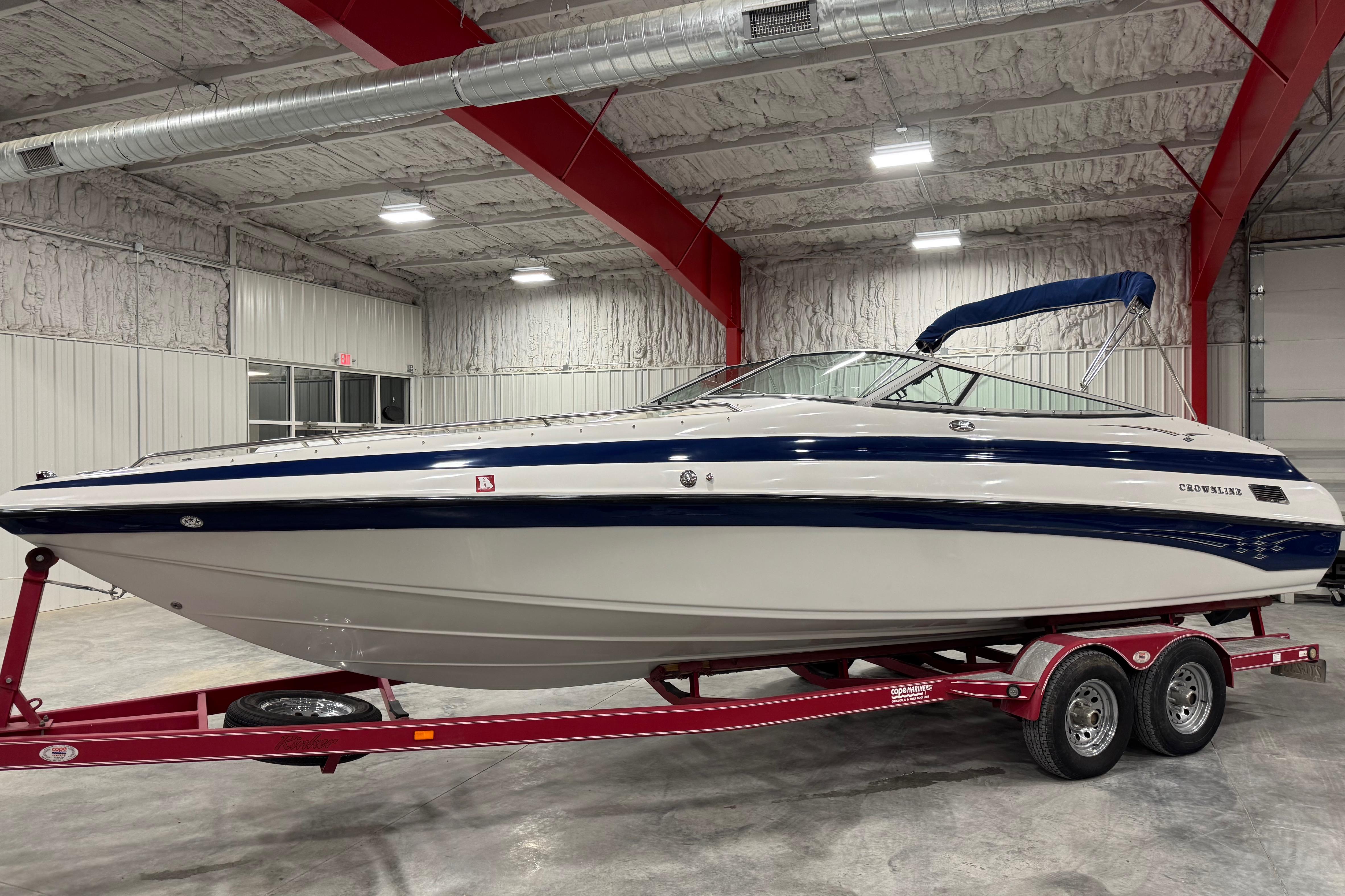 Crownline 266 BR 2004 Crownline 266 BR boat on red trailer in indoor storage facility.