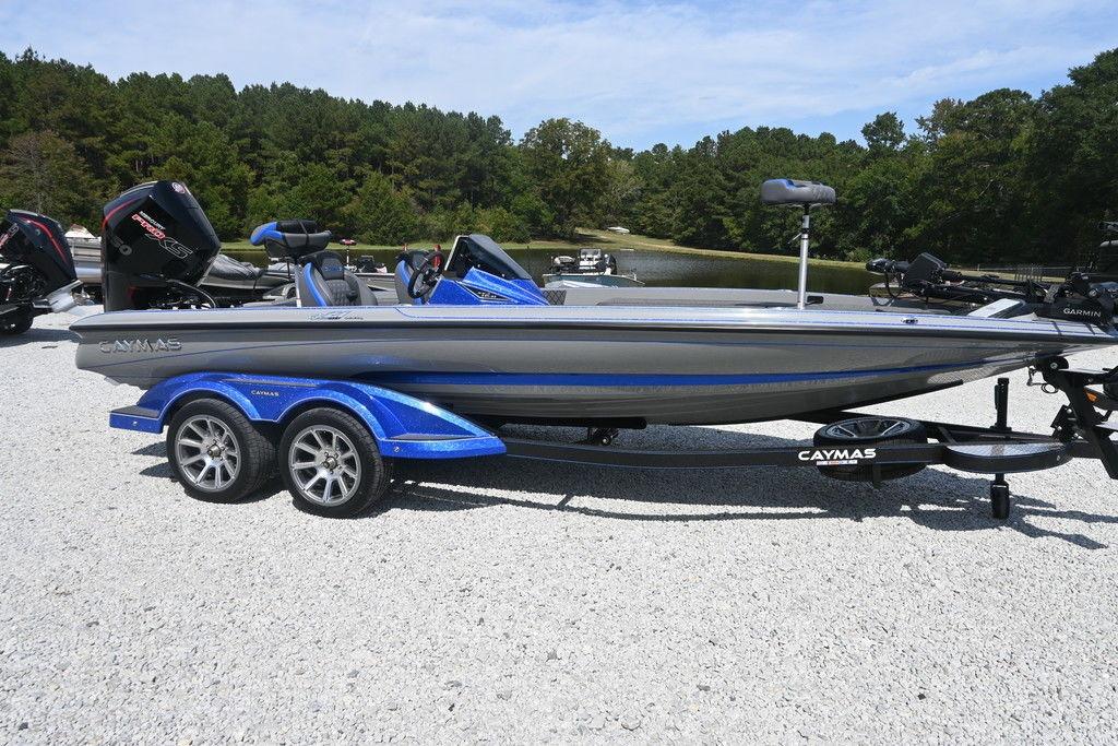 Caymas CX21 2026 Caymas CX21 boat on trailer, parked on gravel near a lake and trees.