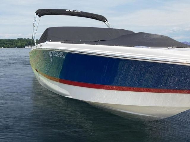 Four Winns H210 2018 Four Winns H210 boat on calm water, featuring sleek design and vibrant colors.