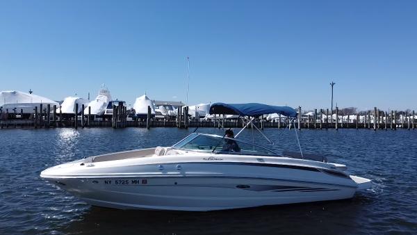 Sea Ray 240 Sundeck 2011 Sea Ray 240 Sundeck boat on water near marina with blue sky.