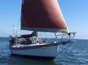 Hans Christian 38 1986 Hans Christian 38 sailboat with red sails on open water.