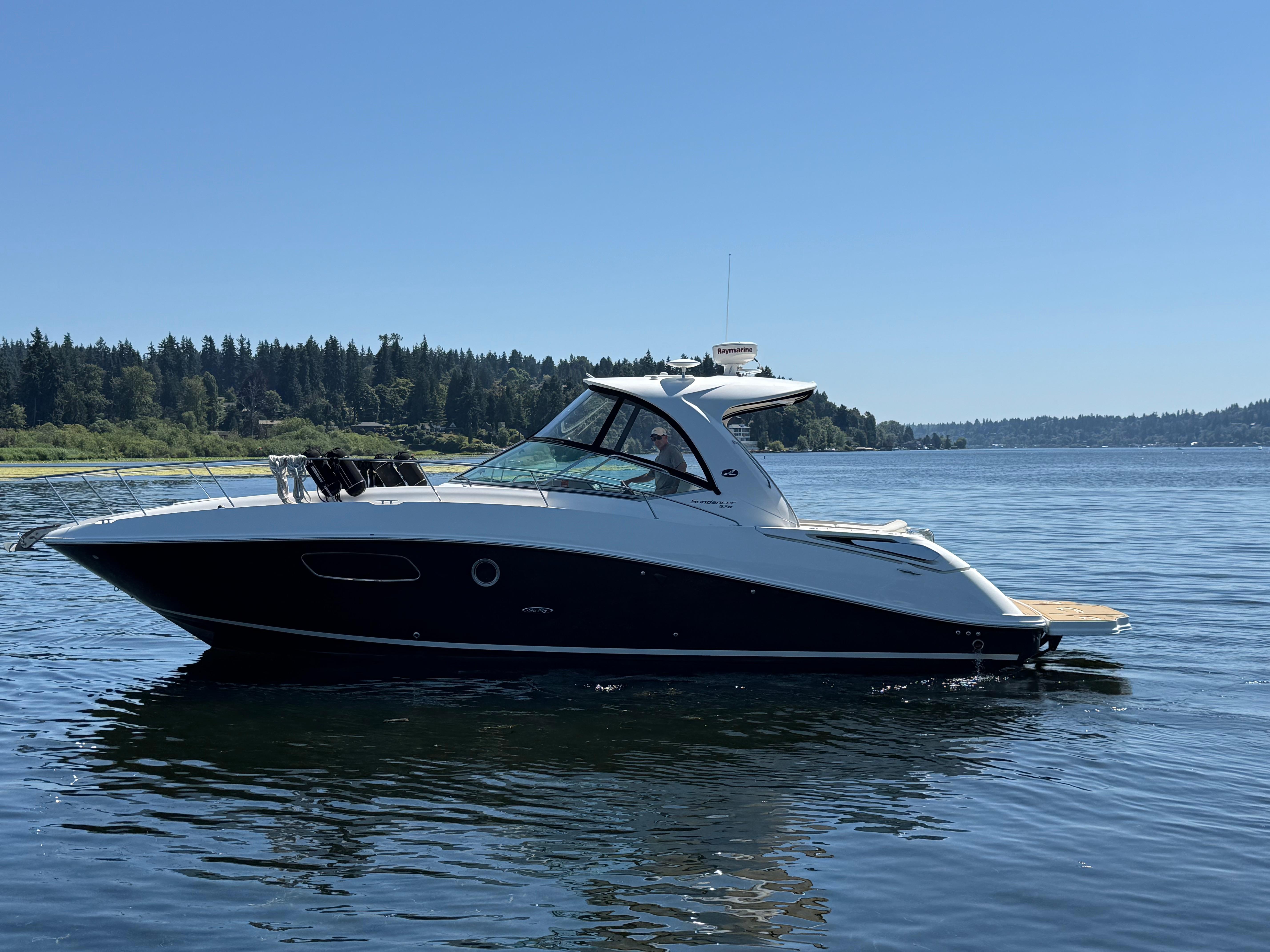 Sea Ray 370 Sundancer 2012 Sea Ray 370 Sundancer yacht cruising on a serene lake under clear blue skies.