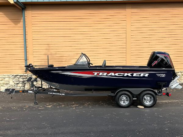 Tracker Targa V-19 WT 2025 Tracker Targa V-19 WT boat on trailer, parked against wooden wall.