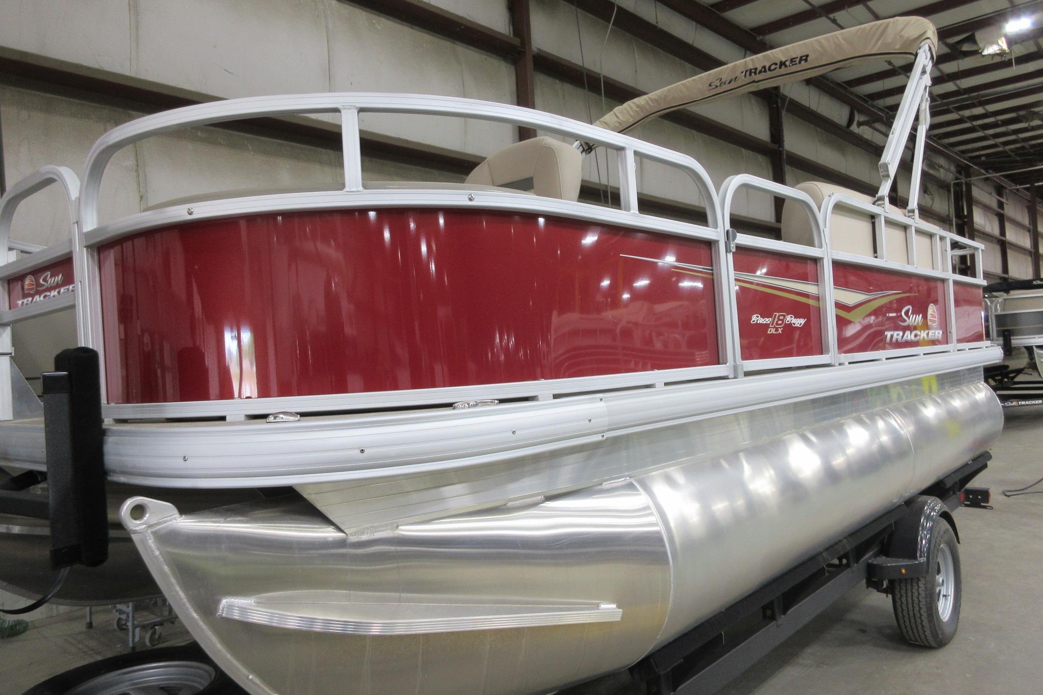 Sun Tracker Bass Buggy 18 DLX 2025 Sun Tracker Bass Buggy 18 DLX pontoon boat in a showroom.