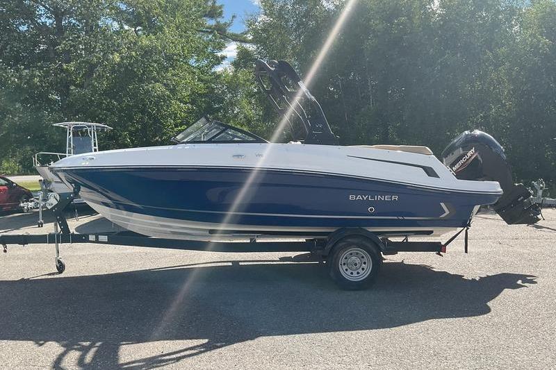 Bayliner VR5 OB 2025 Bayliner VR5 OB boat on trailer, parked outdoors under sunlight.
