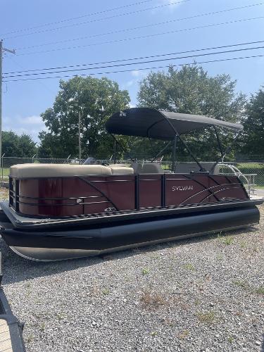 Sylvan Mirage X-1 CLZ DH 2024 Sylvan Mirage X-1 CLZ DH pontoon boat with canopy on gravel lot.