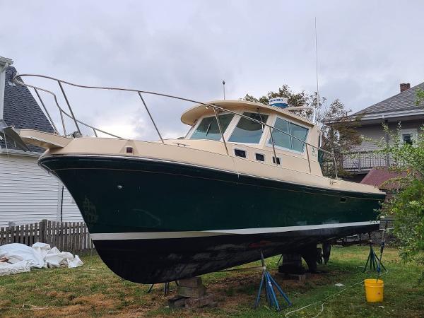 Albin 28 Tournament 1998 Albin 28 Tournament boat on land, green hull, beige cabin, residential background.