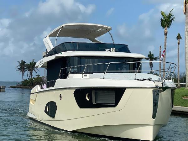 Absolute NAVETTA 48 2020 Absolute NAVETTA 48 yacht cruising on a tropical waterway with palm trees.