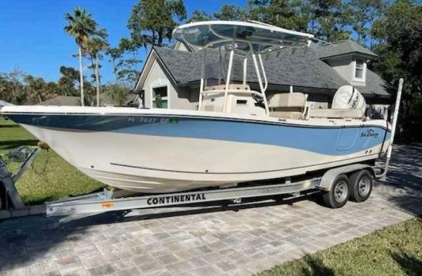 Sea Chaser 24 HFC 2018 Sea Chaser 24 HFC boat on trailer, parked in driveway, surrounded by trees.