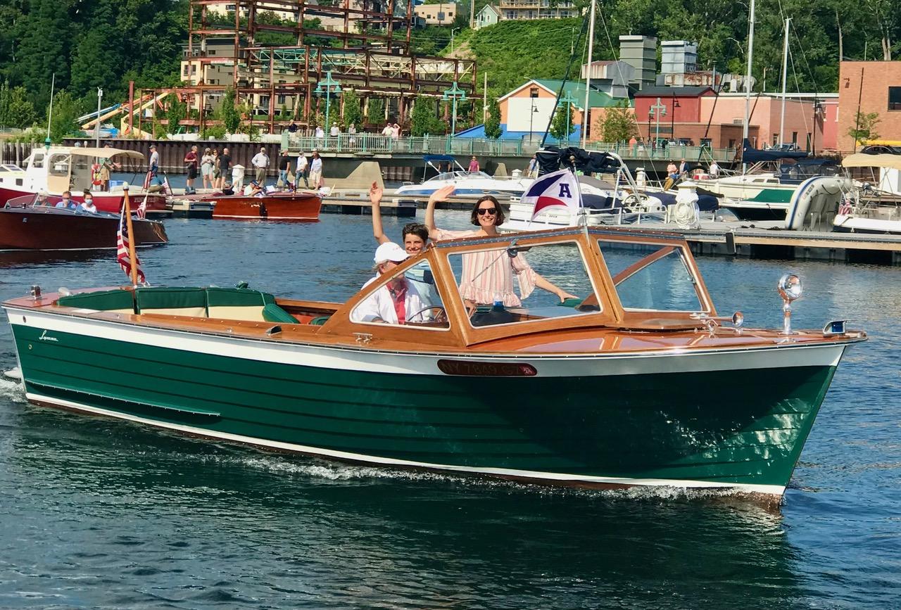 Lyman 25 Sleeper 1964 Lyman 25 Sleeper boat cruising in a lively marina, with passengers waving.
