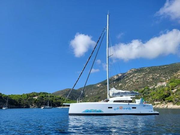 Marsaudon Composites TS/ORC 42 2023 Marsaudon Composites TS/ORC 42 catamaran sailing in a scenic coastal bay.