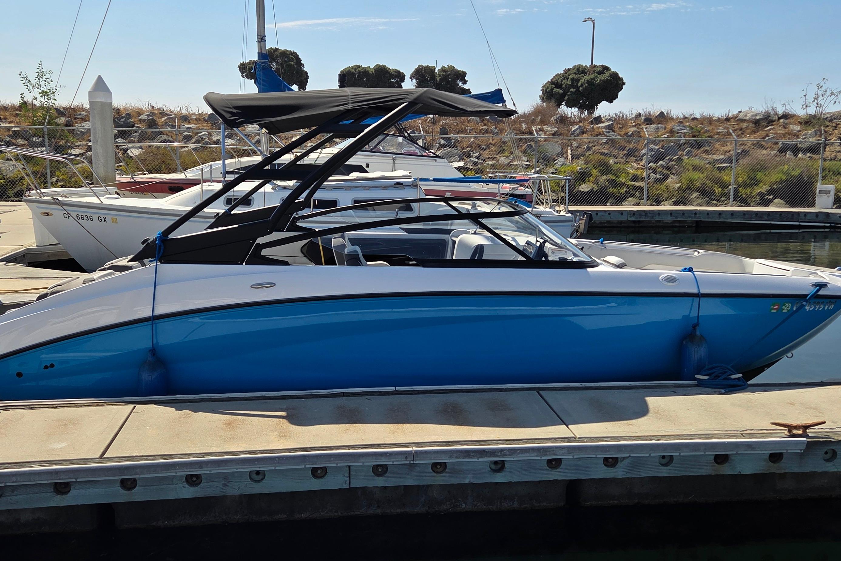 Yamaha Boats AR250 2023 Yamaha AR250 boat docked at marina, featuring sleek blue and white design.