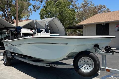 Mako Pro Skiff 17 CC 2025 Mako Pro Skiff 17 CC boat on trailer, parked outdoors under clear sky.