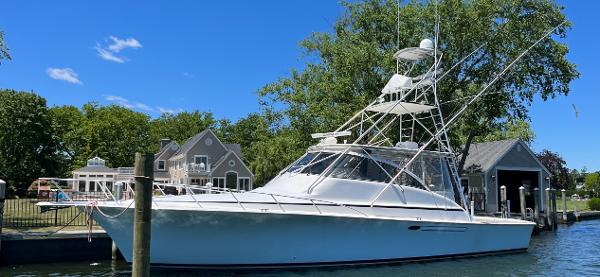 Ocean Yachts 48 Express 1998 Ocean Yachts 48 Express docked near waterfront homes, clear blue sky.