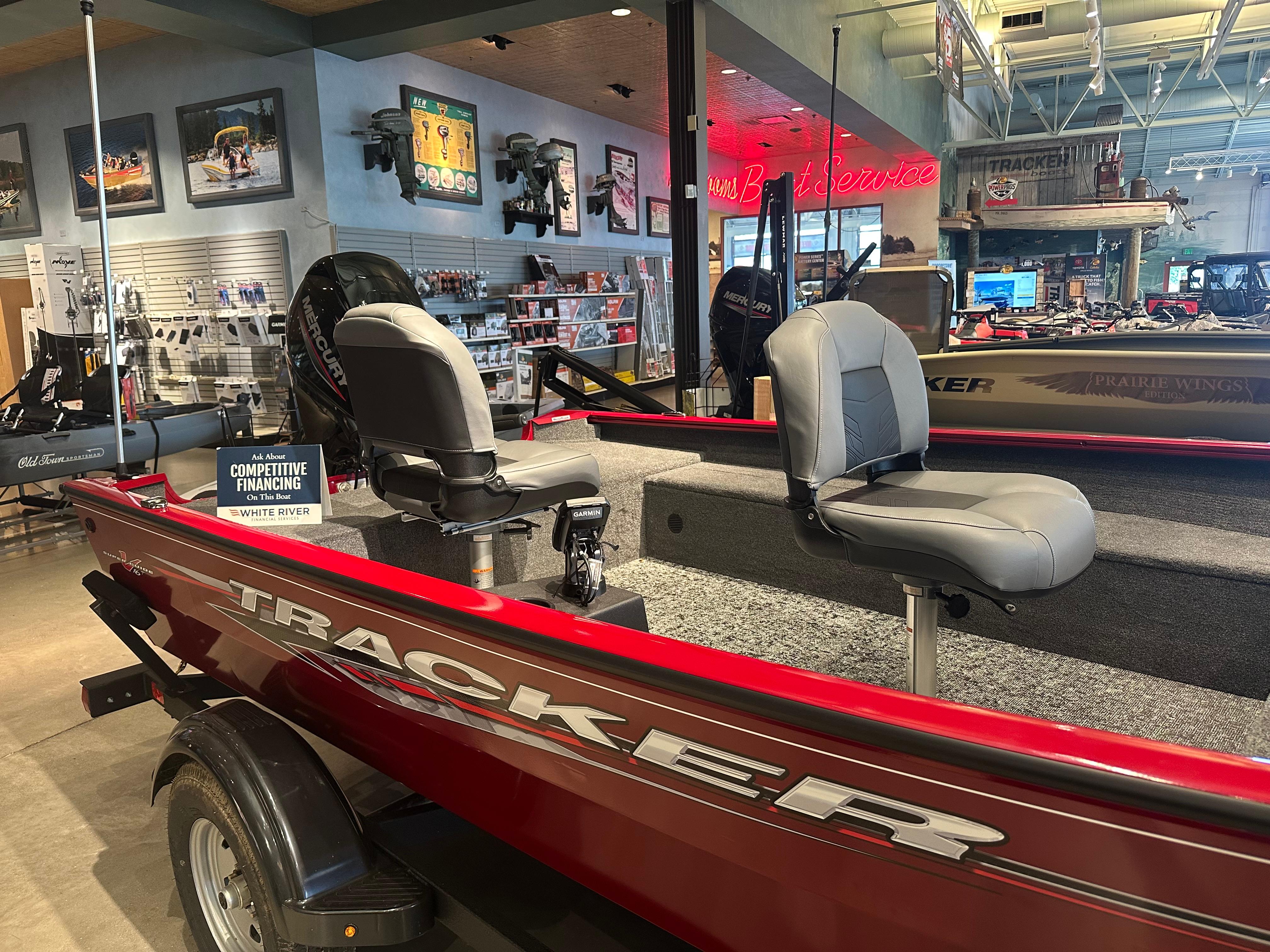 Tracker Super Guide V-16 T 2025 Tracker Super Guide V-16 T boat displayed in showroom with competitive financing sign.