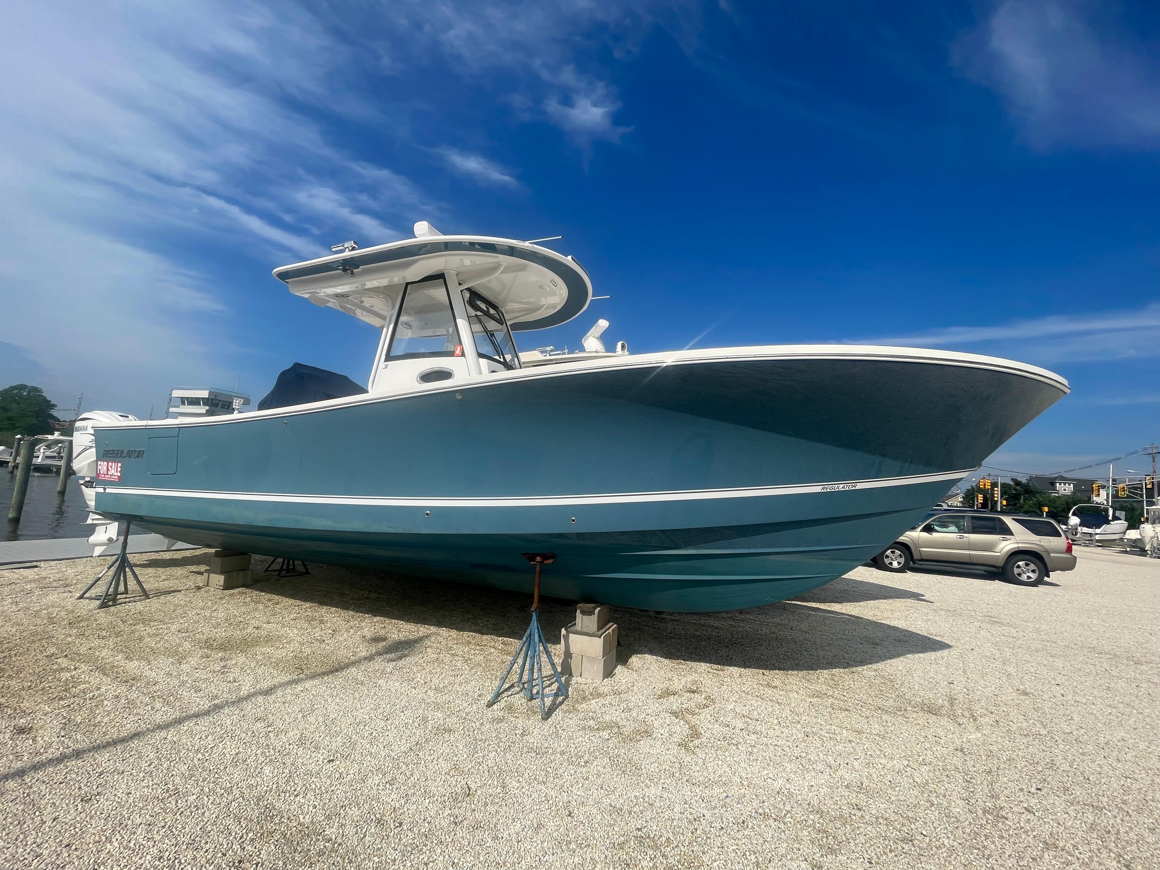 Regulator 31 2022 Regulator 31 boat on display, blue hull, clear sky background.