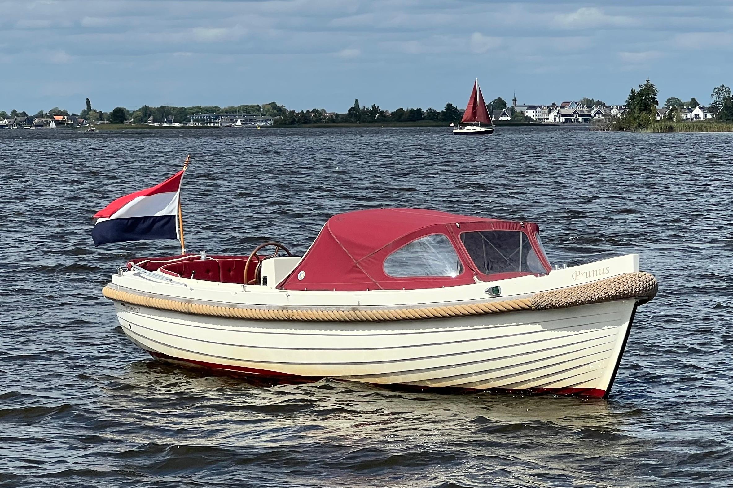 Interboat 21 Sloep 2003 Interboat 21 Sloep with red canopy on a lake, Dutch flag waving.
