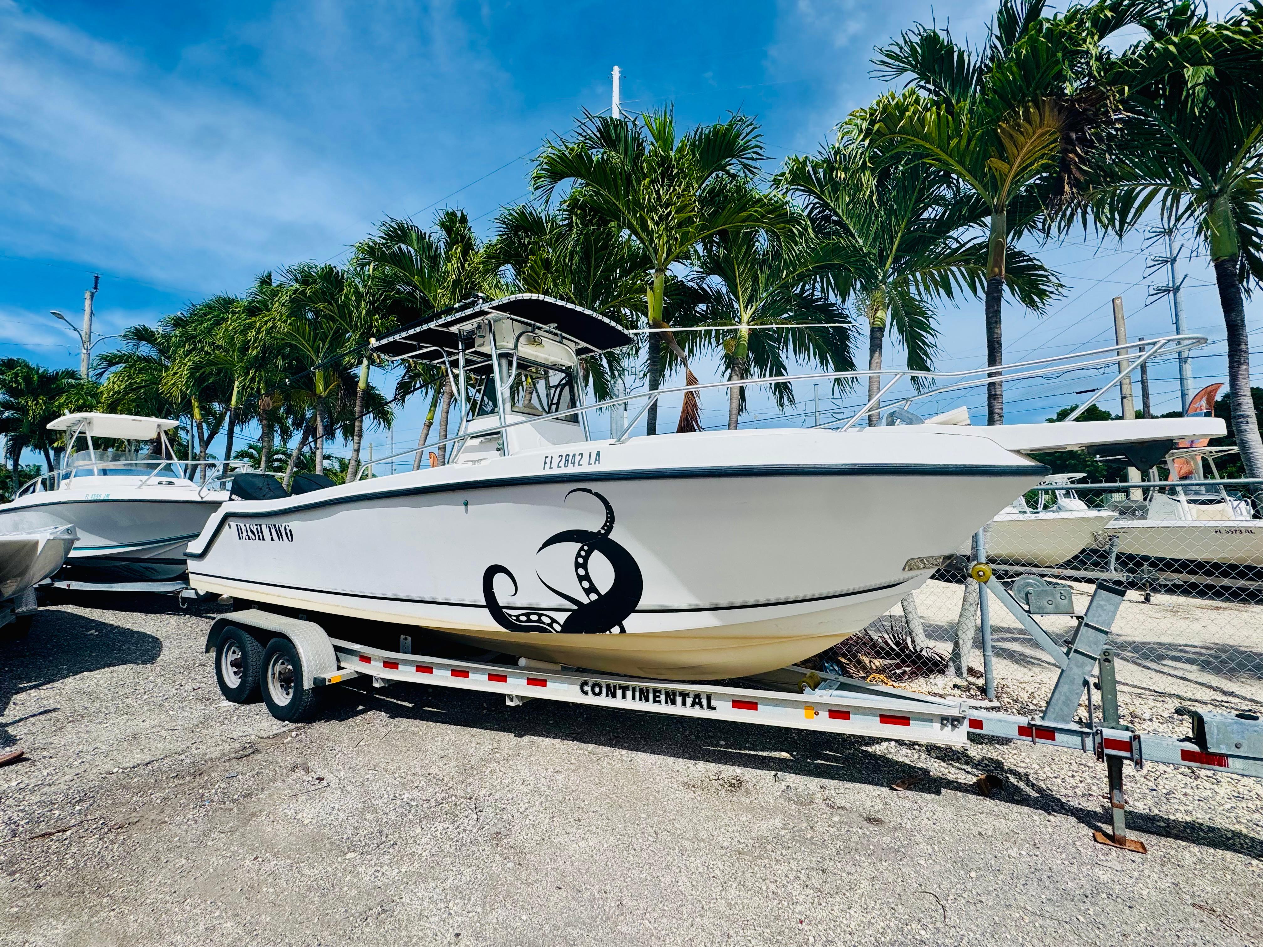 Mako 252 Center Console 1998 Mako 232 Center Console boat on trailer, palm trees in background.