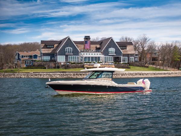 Chris-Craft Calyspo 35 CP 2024 Chris-Craft Calypso 35 CP boat cruising near a large waterfront house.