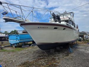 Marinette 37 Motor Yacht 1988 Marinette 37 Motor Yacht on stands, ready for maintenance under a cloudy sky.