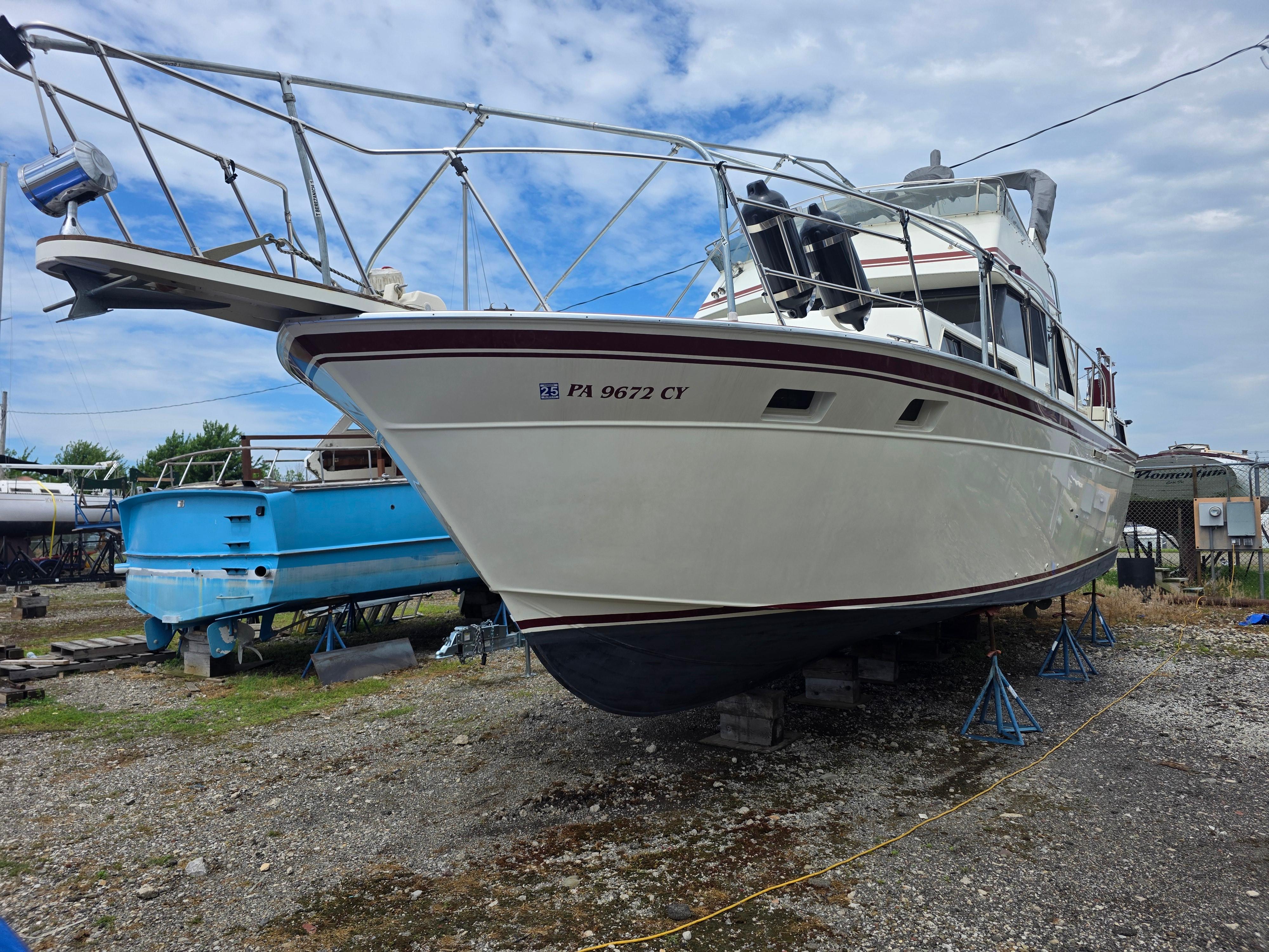 Marinette 37 Motor Yacht 1988 Marinette 37 Motor Yacht on stands, ready for maintenance under a cloudy sky.
