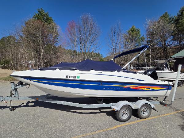Bayliner 217 Deck Boat 2007 Bayliner 217 Deck Boat on trailer, parked outdoors with trees in background.