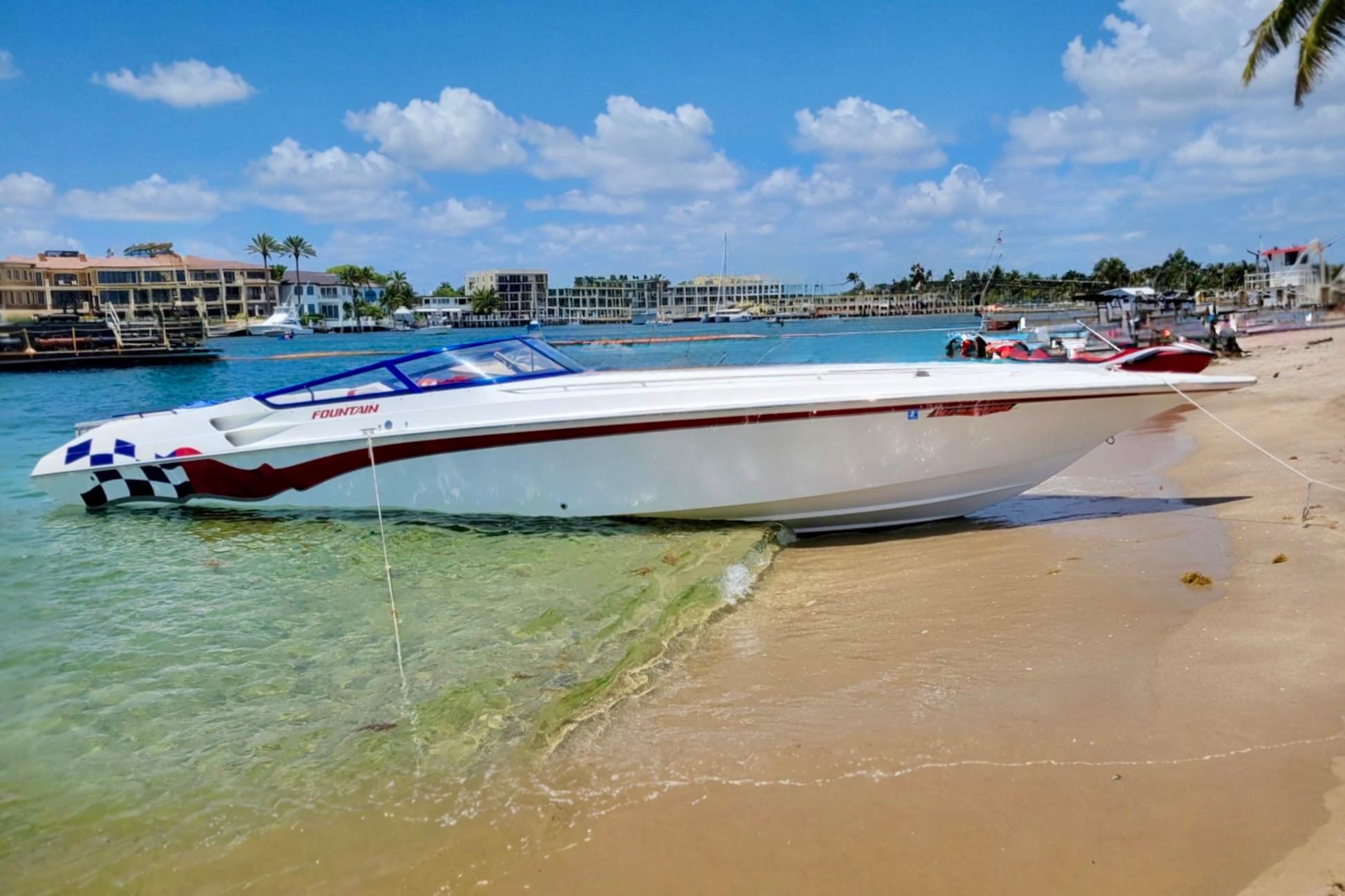 Fountain 38 Lightning 2000 Fountain 38 Lightning boat on sandy beach with clear blue sky.