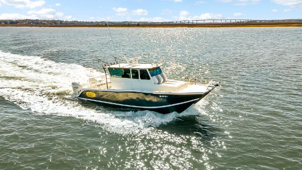 Custom Nerowalker Custom Nerowalker 2024 boat cruising on a sunny day, with sparkling water and distant bridge.