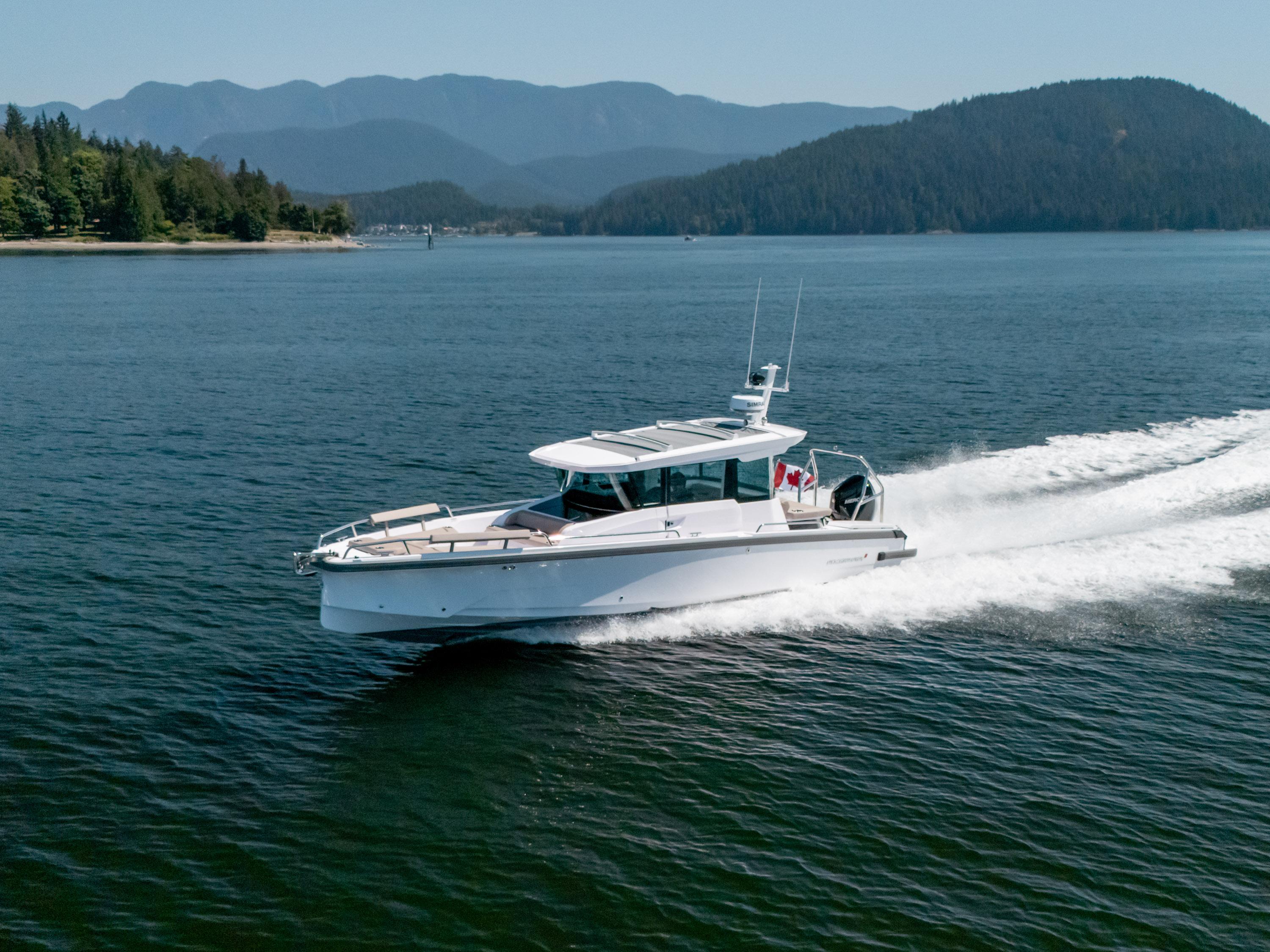 Axopar 29XC Cross Cabin - Aft Cabin 2025 Axopar 29XC Cross Cabin cruising on a scenic lake with forested hills.