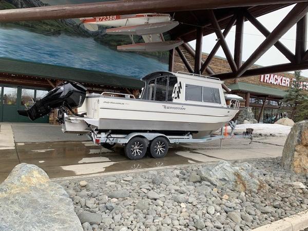 Spartan 240 Maximus Pro 2024 Spartan 240 Maximus Pro boat on a trailer outside a Tracker store.