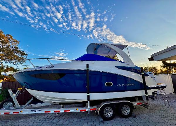Regal 26 XO 2020 Regal 26XO boat on trailer under a vibrant blue sky.