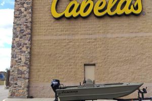 Tracker Grizzly 1648 SC 2026 Tracker Grizzly 1648 SC boat outside Cabela's store.