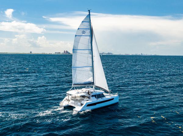 Leopard 42 2025 Leopard 42 catamaran sailing on open ocean under clear blue sky.