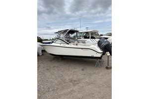 Edgewater 245CX Crossover 2012 Edgewater 245 CX boat on display, parked on gravel under cloudy skies.