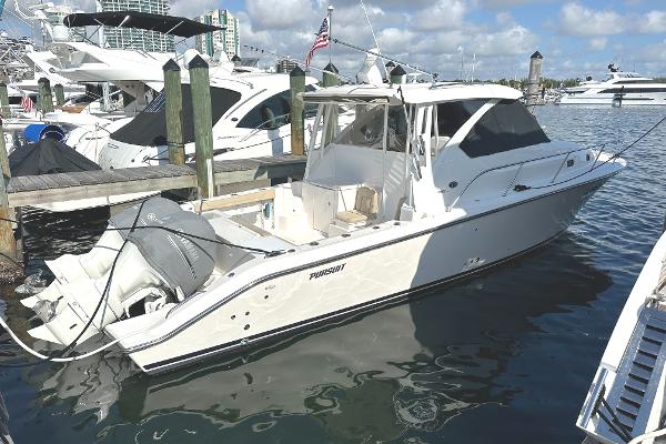 Pursuit OS 355 Offshore 2017 Pursuit OS 355 Offshore boat docked in marina, clear skies, calm water.