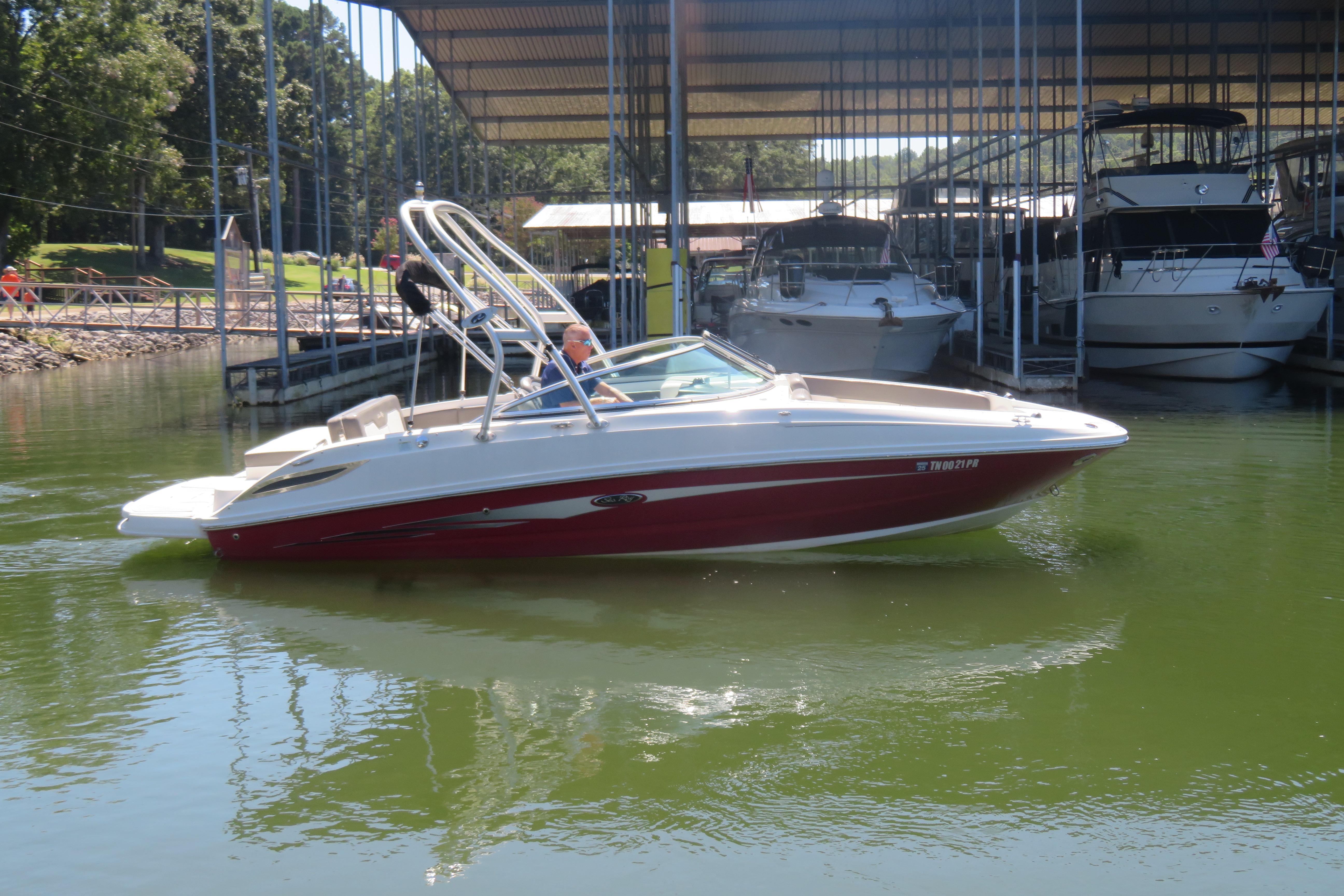 Sea Ray 240 Sundeck 2011 Sea Ray 240 Sundeck boat docked in a marina, surrounded by calm water.