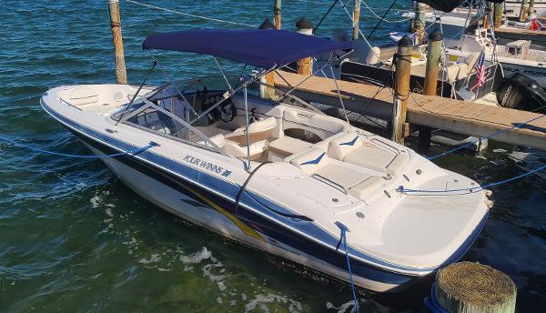 Four Winns 220 Horizon 2007 Four Winns 220 Horizon boat docked in marina with blue canopy.