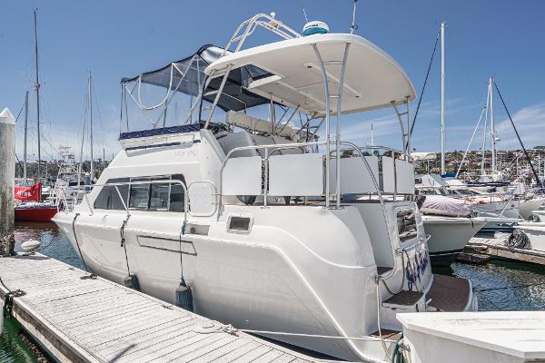Mainship 34 Motor Yacht 1997 Mainship 34 Motor Yacht docked at marina, featuring spacious upper deck and sleek design.