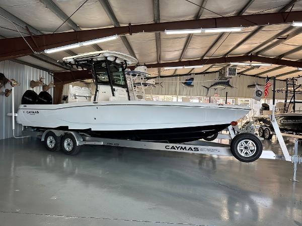 Caymas 281 HB 2024 Caymas 281 HB boat on trailer in showroom, side view.