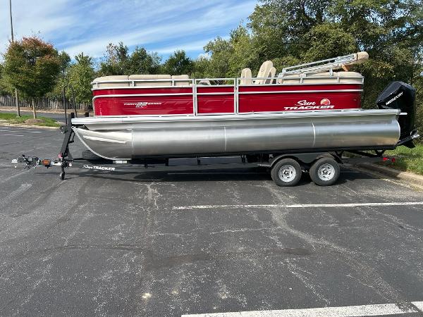 Sun Tracker Party Barge 22 XP3 2025 Sun Tracker Party Barge 22 XP3 pontoon boat on trailer in parking lot.
