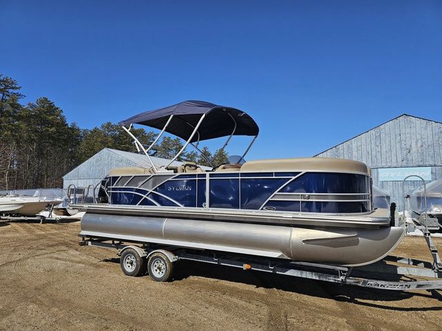 Sylvan Mirage 8522 LZ 2025 Sylvan Mirage 8522 LZ pontoon boat on trailer, blue and beige, outdoor setting.
